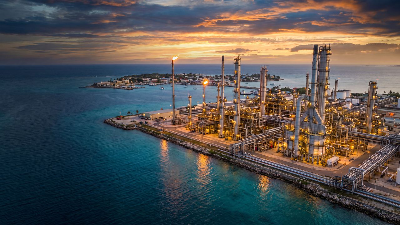 Vista aérea de una refinería costera en una isla caribeña al atardecer
