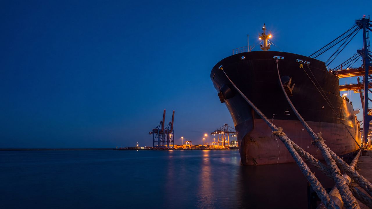Bow of a cargo ship moored at a port at night